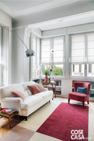 soggiorno con divano bianco e poltrona color fragola