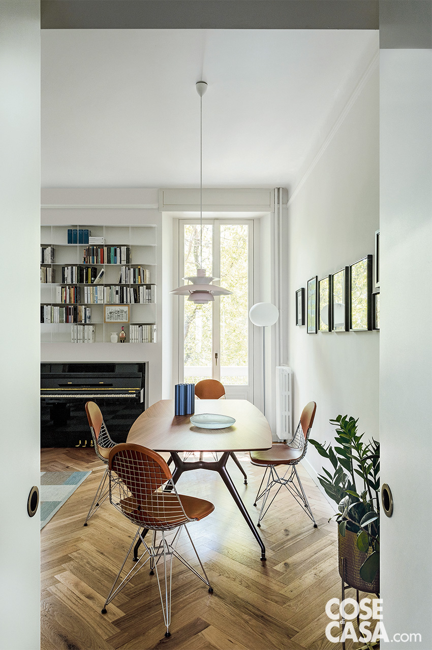 Zona pranzo elegante – Tavolo in noce con sedute iconiche e lampada sospesa scenografica Zona pranzo elegante – Tavolo in noce con sedute iconiche e lampada sospesa scenografica