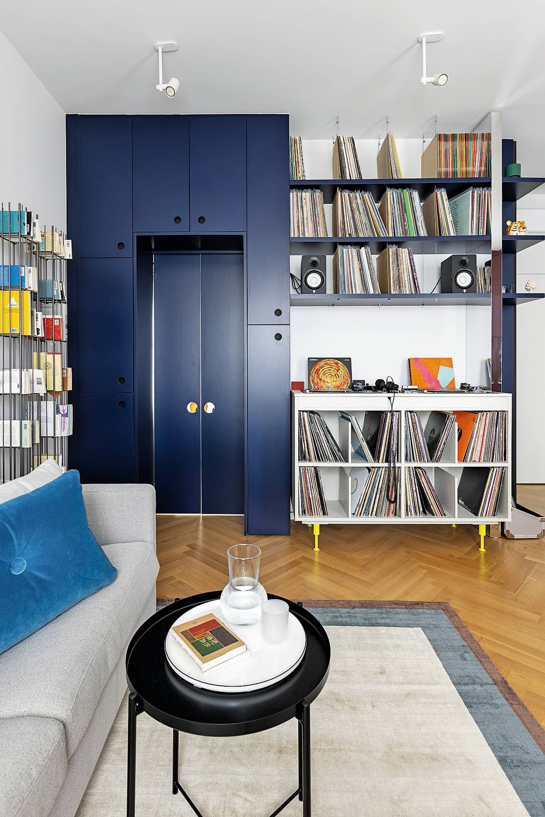 Intorno alla porta, una composizione a tutt'altezza integra il varco di passaggio con contenitori  di varie dimensioni chiusi da ante e incornicia la consolle con mensole a giorno che ospitano i vinili. Foto di Cristina Galliena Bohman. Intorno alla porta, una composizione a tutt'altezza integra il varco di passaggio con contenitori  di varie dimensioni chiusi da ante e incornicia la consolle con mensole a giorno che ospitano i vinili. Foto di Cristina Galliena Bohman.