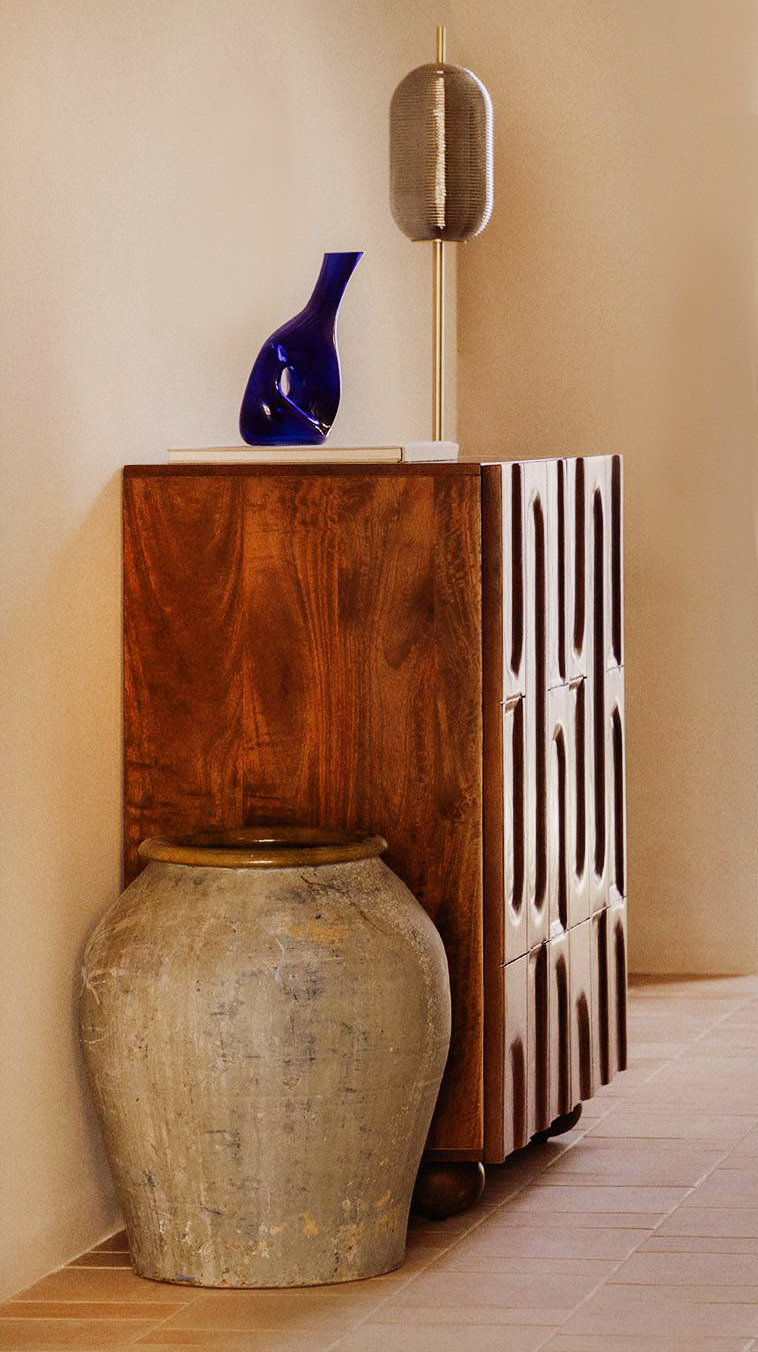 La profondità ridotta della credenza bassa Even di The Masie consente di sistemarla facilmente in un ingresso o in un corridoio. La struttura compatta con due ante a battente è completamente realizzata in legno di mango; all'interno contiene due ripiani. I sostegni hanno una forma arrotondata che riprende il decoro delle ante.  Misura L 90 x P 47 x H 94 cm. Prezzo 399,95 euro.  https://www.themasie.com