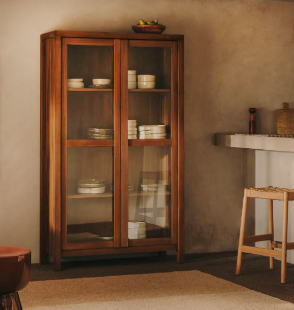 Pregiato legno massiccio di teak con effetto spazzolato per la credenza/vetrina Sashi di Kave Home che può essere usata per riporre le stoviglie o come dispensa a vista. Le due ante sono in vetro temperato trasparente. Misura L 110 x P 40 x H 185 cm. Prezzo 1.970 euro https://kavehome.com