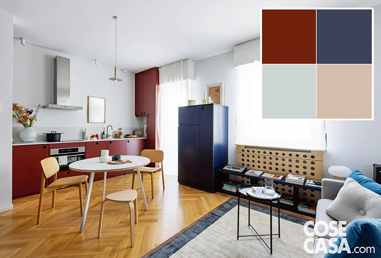 La zona giorno di questo appartamento si presenta con un unico spazio che ospita salotto e cucina.
Per l'angolo cottura, che è a vista e in composizione lineare a occupare una sola parete, è stato scelto un laminato in color rosso bordeaux. Questa tonalità si armonizza molto bene sia con il parquet in rovere, richiamato dal legno chiaro delle sedie e del copricalorifero, sia con il blu degli altri mobili, dei cuscini e del bordo del tappeto, sia infine con il tessuto grigio del divano, con un risultato di un ambiente allo stesso tempo luminoso e colorato, ma senza contrasti cromatici eccessivi. Foto: Cristina Galliena Bohman – Styling: Francesca Martinez. Progetto: Flatwig Studio, Erica Agogliati e Francesca Avian, Milano – http://www.flatwig.com.