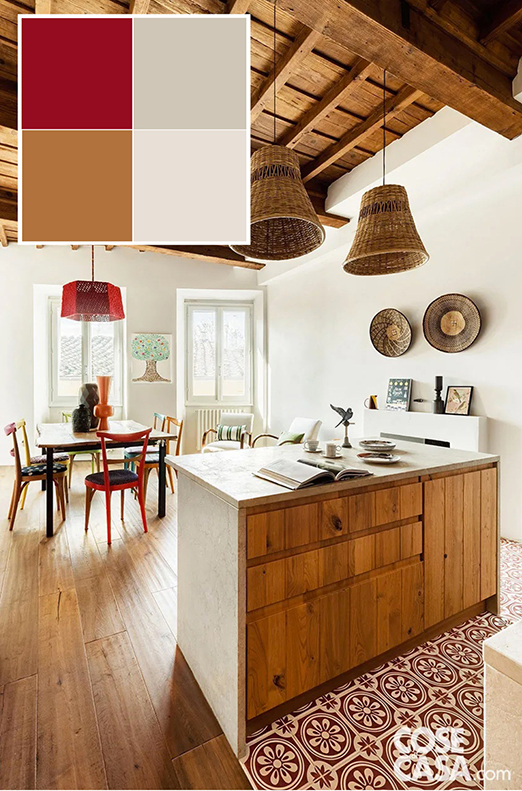 Questa cucina è inserita come angolo cottura in un open space che comprende anche la zona pranzo. L'ambiente è dominato dal legno, presente nel parquet in rovere, nel soffitto a cassettoni con travi a vista, nello stesso mobile della cucina, nonché nelle sedie e nel tavolo della zona pranzo, con l'inserimento di lampade in paglia di fattura artigianale a creare un effetto rustico e country. In questo insieme sono stati inseriti degli accenti di rosso, primo fra tutti il bellissimo pavimento dell'area cottura: si tratta di piastrelle in gres effetto cementine a disegni bianchi e rossi. Il colore qui è usato sia per definire e sottolineare l'area funzionale, sia per personalizzare l'ambiente. Foto: Studio Daido. Styling: Studio Wolo. Progetto: O/A Officina Abitare, architetti Sara Bartolini e Matteo Pierattini, via Cairoli 41, Firenze – officinaabitare.com.