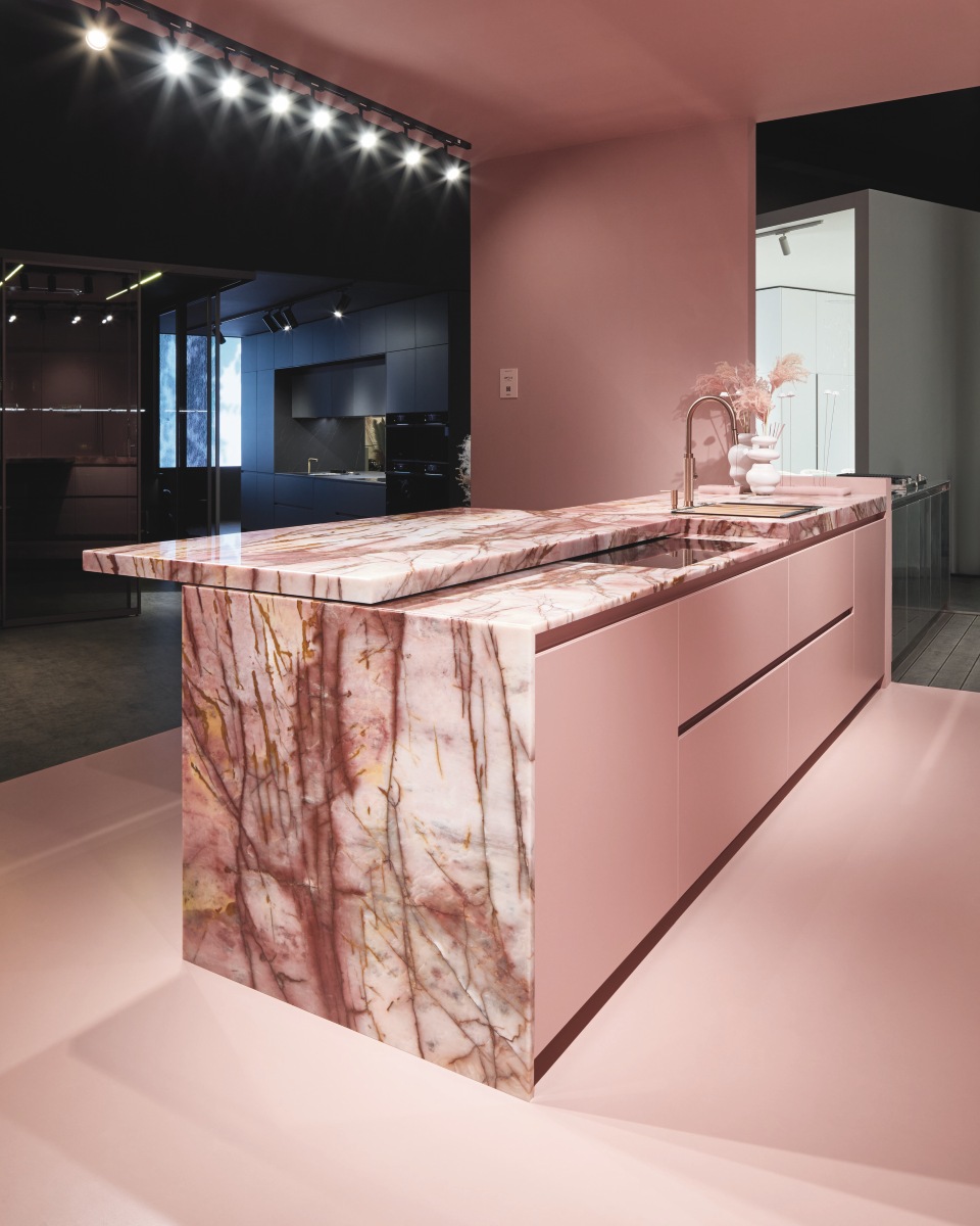 Linee pulite e superfici laccate opache in rosa disegnano uno spazio raffinato e contemporaneo per la cucina  Loft 2.2 - Line di Arrex. Protagonista il piano snack scorrevole da 105 cm, integrato nel modulo base, perfetto per creare in un attimo un’area conviviale o di lavoro in più. Le ante scorrevoli rientranti nascondono una seconda cucina, mentre le colonne cannettate in MDF da 22 mm spessore, con nuova maniglia a tutta altezza, aggiungono ritmo e texture. Dettagli come la gola inclinata a 30°, i cassetti Blum Legrabox Inox con sponda in vetro e il top in quarzite Cosmopolitan lucida completano la composizione. www.arrex.it