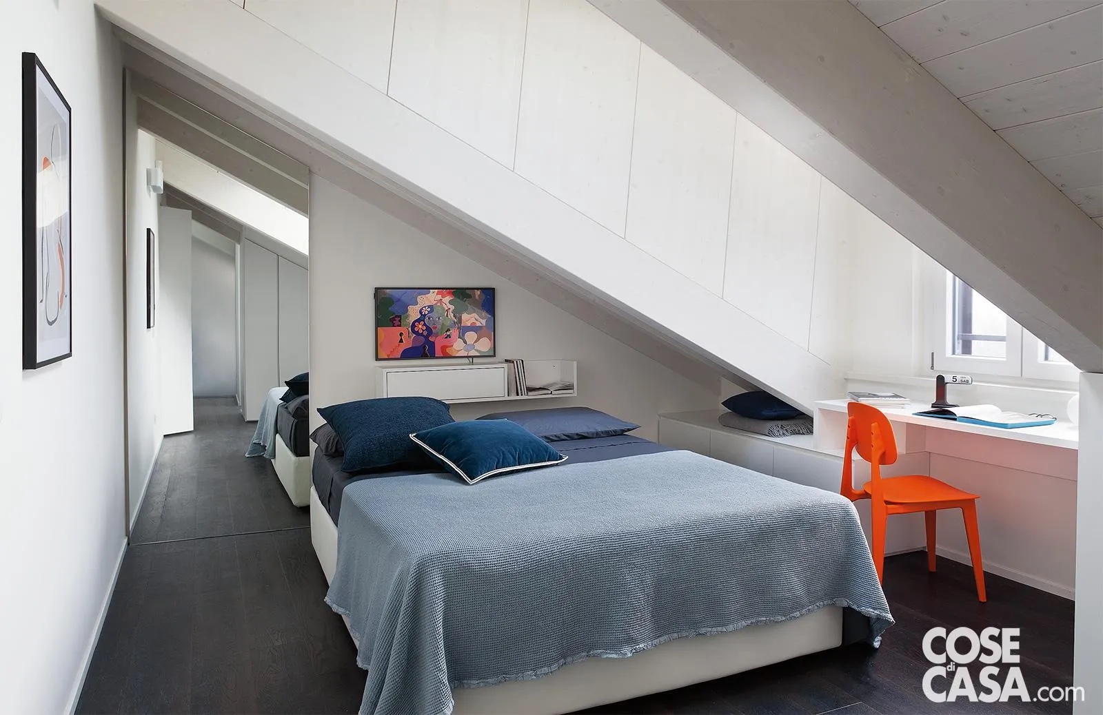 Nella camera da letto la parte della parete di altezza ridotta, situata a fianco del letto matrimoniale, è sfruttata al centimetro con mobili bassi e con una scrivania, di colore bianco per accrescere la luminosità e valorizzare quella esistente.
Il ripiano della scrivania è inquadrato dalla finestra che dona tanta luce e rende fruibile al meglio la postazione studio, ravvivata dalla presenza di una sedia di colore arancione che spicca su tutto il resto.
Progetto Bdstudio arch. Alberto Barbieri, Via Caravaggio 2, Milano Segrate, Tel. 02/94343531 http://www.bdstudio.com - Foto Cristina Fiorentini - Styling Laura Mauceri