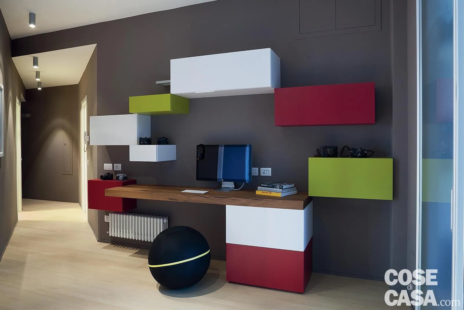 In questa casa, per realizzare un angolo studio è stato sfruttato un ambiente di raccordo centrale tra i due spazi della zona giorno e della zona notte. Il disimpegno, infatti, per via della forma irregolare e dell'assenza di aperture e di luce naturale, sarebbe rimasto inutilizzato, se non fosse stata pensata questa soluzione intelligente. Lungo la parete dipinta in grigio scuro, è stata collocata una composizione di vari colori formata da più moduli contenitori di diversa grandezza e da un ampio ripiano in legno che funge da scrivania.
Progetto d'arredo Studio Patetta, Barbara Piccinno & Niccolò Patetta, Milano, Tel. 02/36554145.
Foto Cristina Fiorentini. Styling Laura Mauceri. In questa casa, per realizzare un angolo studio è stato sfruttato un ambiente di raccordo centrale tra i due spazi della zona giorno e della zona notte. Il disimpegno, infatti, per via della forma irregolare e dell'assenza di aperture e di luce naturale, sarebbe rimasto inutilizzato, se non fosse stata pensata questa soluzione intelligente. Lungo la parete dipinta in grigio scuro, è stata collocata una composizione di vari colori formata da più moduli contenitori di diversa grandezza e da un ampio ripiano in legno che funge da scrivania.
Progetto d'arredo Studio Patetta, Barbara Piccinno & Niccolò Patetta, Milano, Tel. 02/36554145.
Foto Cristina Fiorentini. Styling Laura Mauceri.