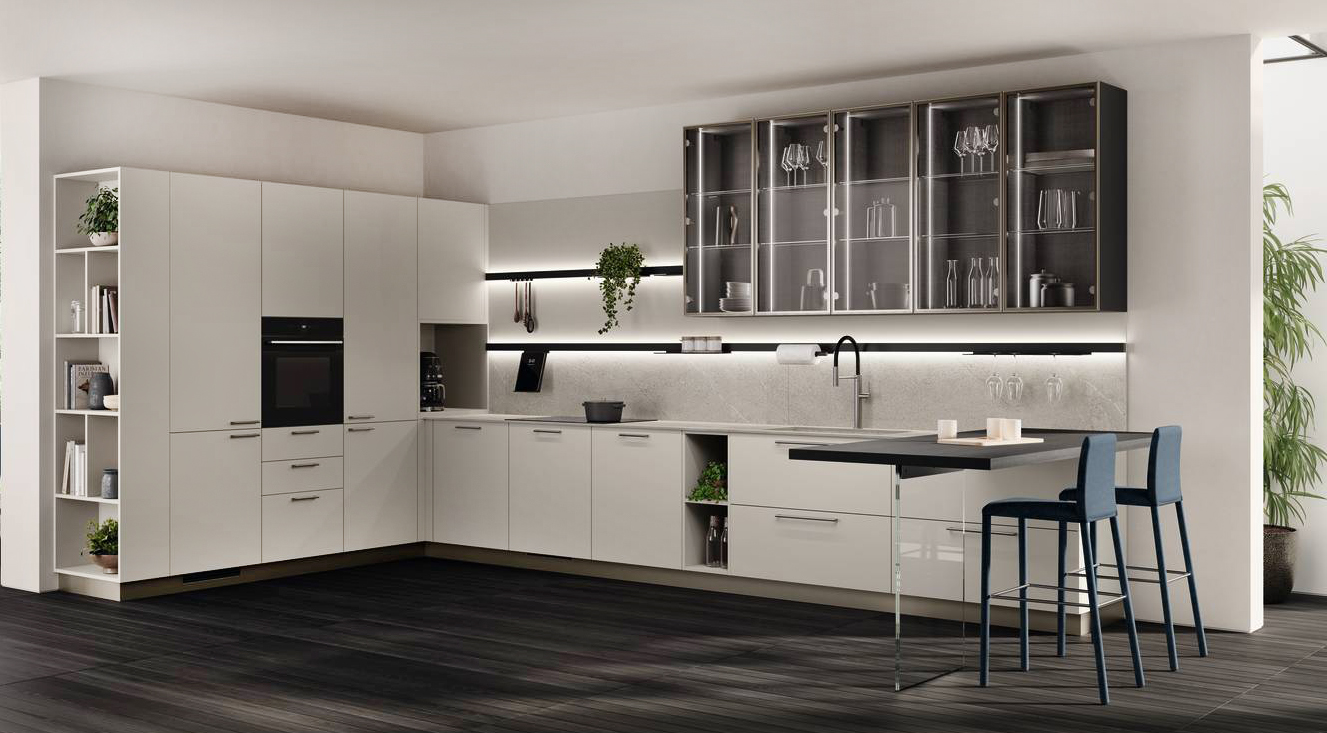 Ha le ante in laccato opaco Grigio Chiaro la cucina Moda di Scavolini che si sviluppa angolarmente dando vita ad una zona cucina aperta, ma separata dal living. I pensili a sviluppo verticale hanno le ante con il telaio Alluminio nella finitura Champagne in vetro Bronzo trasparente. Il piano di lavoro è in Gres Porcellanato Lighstone; il top del banco colazione è in Laminato Burnt Wood. La bassa portaccessori Sign  in alluminio è dotata di luce. Prezzo su richiesta. https://www.scavolini.com Ha le ante in laccato opaco Grigio Chiaro la cucina Moda di Scavolini che si sviluppa angolarmente dando vita ad una zona cucina aperta, ma separata dal living. I pensili a sviluppo verticale hanno le ante con il telaio Alluminio nella finitura Champagne in vetro Bronzo trasparente. Il piano di lavoro è in Gres Porcellanato Lighstone; il top del banco colazione è in Laminato Burnt Wood. La bassa portaccessori Sign  in alluminio è dotata di luce. Prezzo su richiesta. https://www.scavolini.com