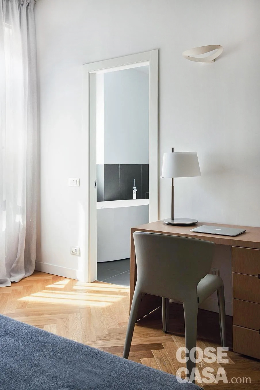 Questa camera da letto, che include anche un bagno privato interno, si presenta come molto luminosa per via di una grande finestra e possiede un'area di passaggio abbastanza spaziosa ai piedi del letto.
Qui è stata posizionata una scrivania dotata di cassettiera e completata da una bella poltroncina e da una lampada per illuminare il piano di lavoro: si tratta di una soluzione semplice, tradizionale e molto funzionale.
Progetto arch. Francesca Albertario, Alba Studio, Milano, Tel. 02/94380177 - http://www.alba-studio.com - Foto Cristina Galliena Bohmann - Styling Laura Mauceri