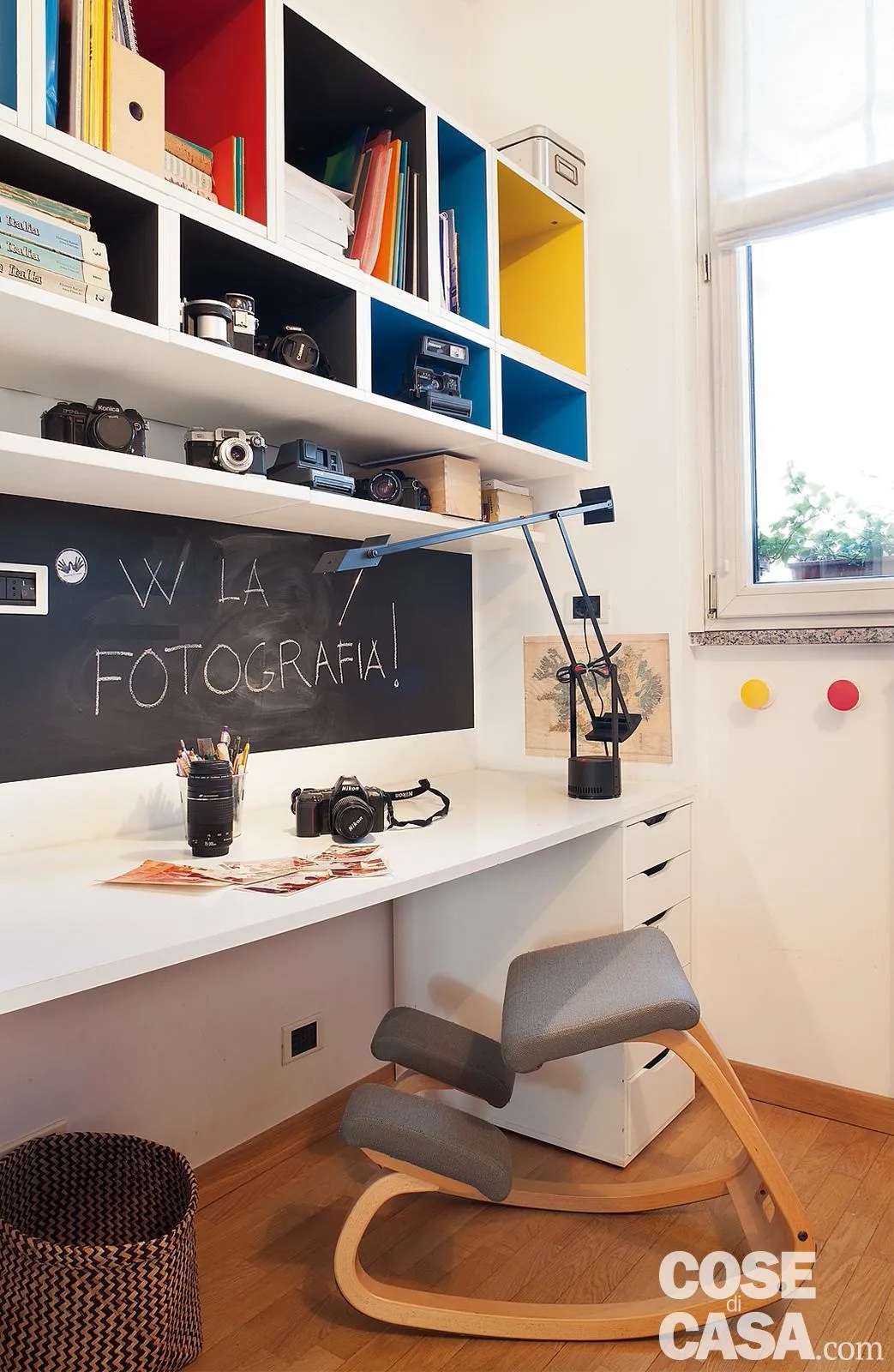 In questa camera da letto è stata posizionata una scrivania con un lungo piano di lavoro che utilizza tutta la parete laterale rispetto alla finestra e che quindi riceve abbondante luce naturale. La scrivania possiede una cassettiera e la completano una lampada orientabile, uno sgabello ergonomico e diversi moduli sospesi per tenere in ordine libri, oggetti e contenitori: una soluzione moderna e funzionale se si ha un po' più di spazio a disposizione.
Progetto arch. Maurizio Garrasi e Cristiana Mercuriali, Milano, Tel. 02/83413550 http://www.garrasi.eu e http://www.studiomercuriali.it - Foto Cristina Fiorentini