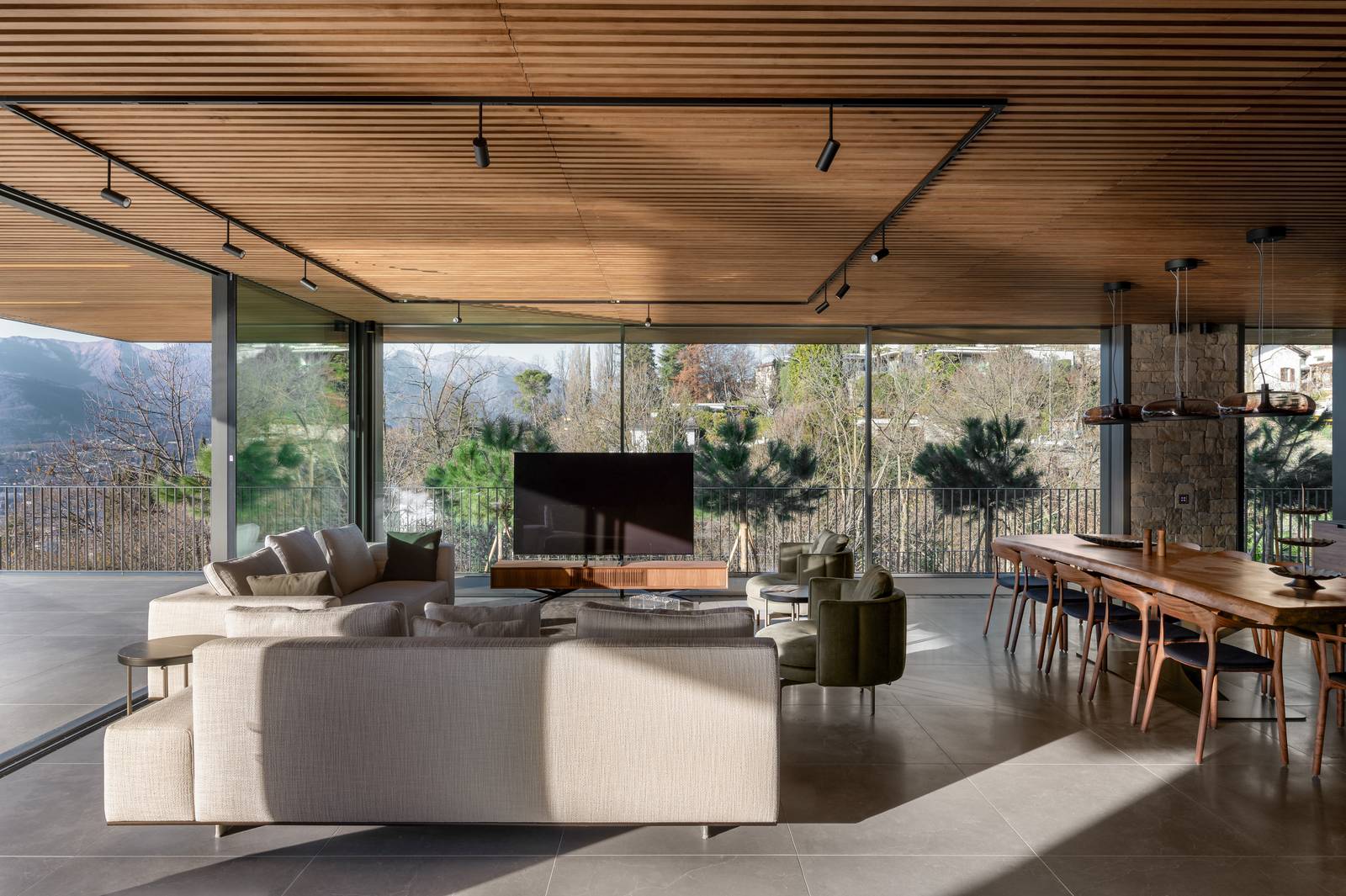 Prospettiva che mostra l'apertura degli spazi della zona giorno, con il soggiorno e la zona pranzo visibili attraverso un design open-space. Anche qui, la pavimentazione Lithos Desert 14mm e le ampie vetrate sono elementi chiave che definiscono l'ambiente. Prospettiva che mostra l'apertura degli spazi della zona giorno, con il soggiorno e la zona pranzo visibili attraverso un design open-space. Anche qui, la pavimentazione Lithos Desert 14mm e le ampie vetrate sono elementi chiave che definiscono l'ambiente.