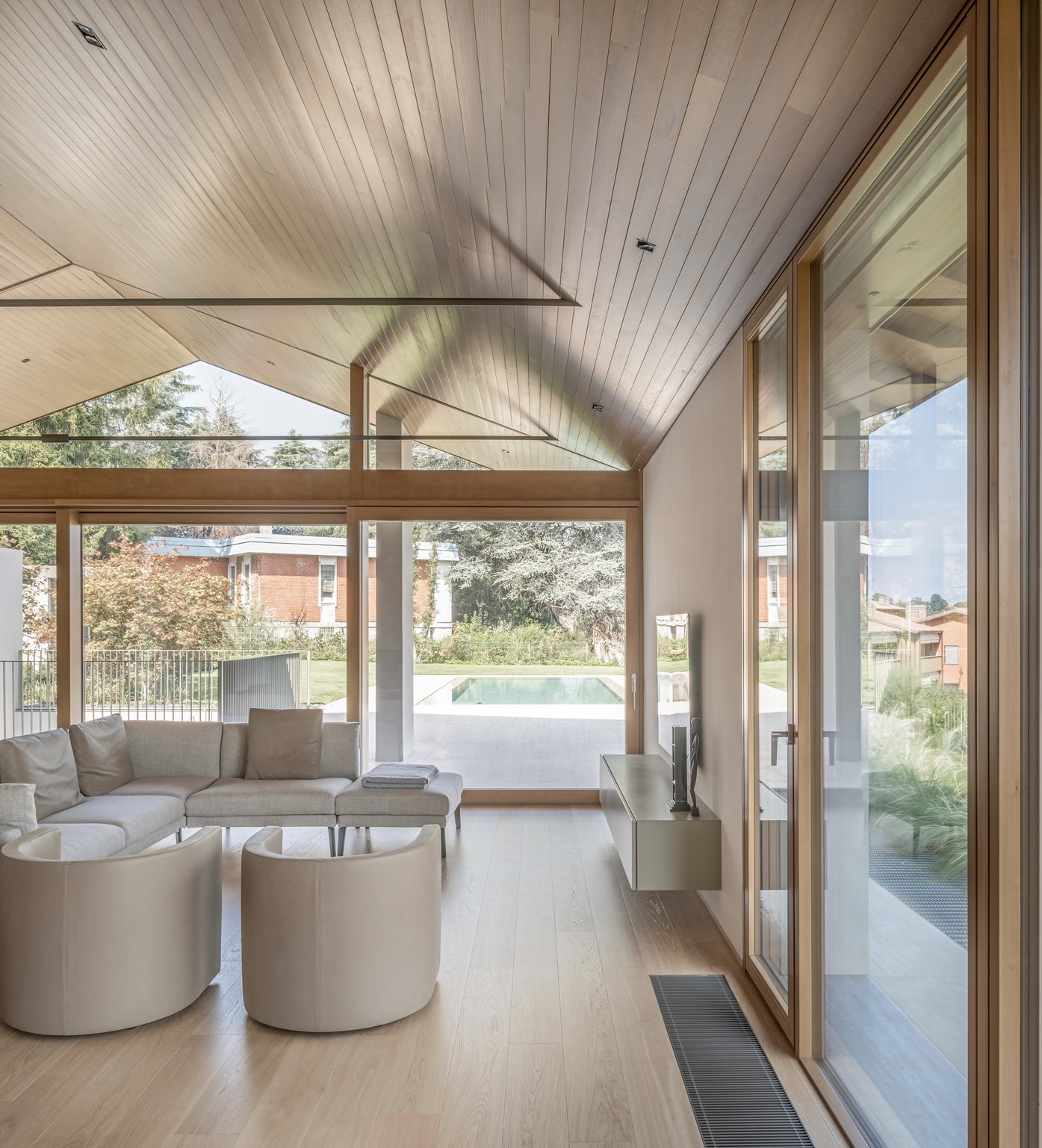 Il salottino con imbottiti chiari che affaccia direttamente sulla piscina.