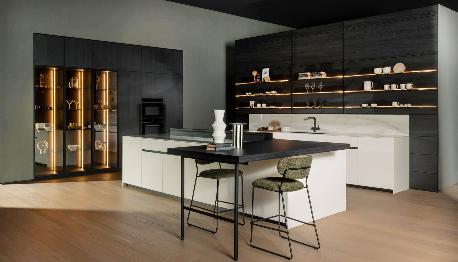 Black & white per la composizione di Arredo3 che unisce elementi del modello Time e del modello Kalì. L'isola di grandi dimensioni è dotata di una doppia fila di moduli così da servire sia la parte operativa sia il living. Le basi sono realizzate in laccato bianco opaco RAL 9010; il top è in Abitum Lincoln Oro Lucido. Il blocco colonne e sopracolonne è in laminato rovere fumé come il piano snack e la boiserie LAB, con mensole illuminate da profili a LED. Prezzo su richiesta. https://www.arredo3.it Black & white per la composizione di Arredo3 che unisce elementi del modello Time e del modello Kalì. L'isola di grandi dimensioni è dotata di una doppia fila di moduli così da servire sia la parte operativa sia il living. Le basi sono realizzate in laccato bianco opaco RAL 9010; il top è in Abitum Lincoln Oro Lucido. Il blocco colonne e sopracolonne è in laminato rovere fumé come il piano snack e la boiserie LAB, con mensole illuminate da profili a LED. Prezzo su richiesta. https://www.arredo3.it