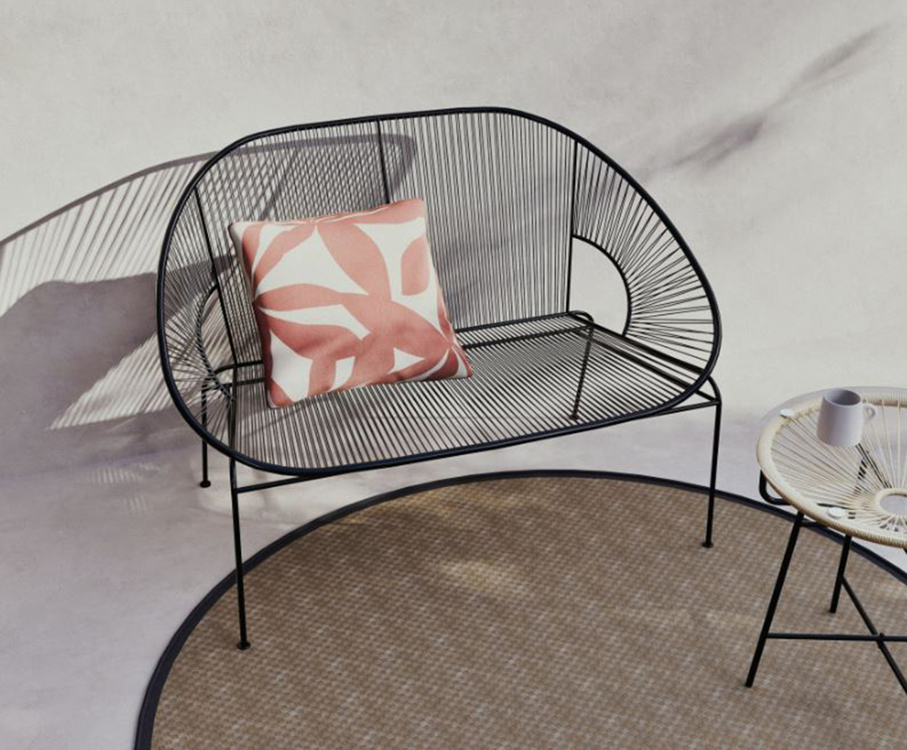 Il divanetto Copacabana di Maisons du Monde, in fili di resina di polietilene e metallo verniciato nero, è impilabile e può essere spOstato facilmente. Inoltre, è resistente al sole e alla pioggia. Misura L 118 x P 73 x H 82 cm. Prezzo 199 euro. https://www.maisonsdumonde.com