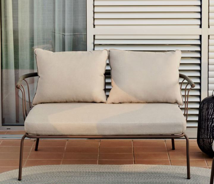 Una leggera struttura in acciaio verniciato marrone per il divanetto da esterno Salguer di Kave Home. Lo schienale è decorato da una corda intrecciata verde; i morbidi cuscini sfoderabili sono inclusi. Misura L 135 x P 70 x H 80 cm. Prezzo 469 euro. https://kavehome.com