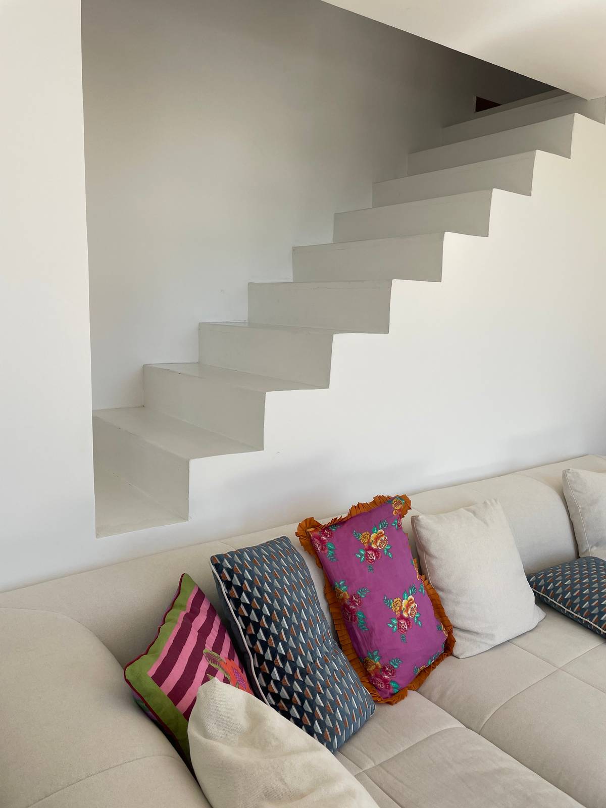 divano bianco con cuscini colorati che interrompono il total white