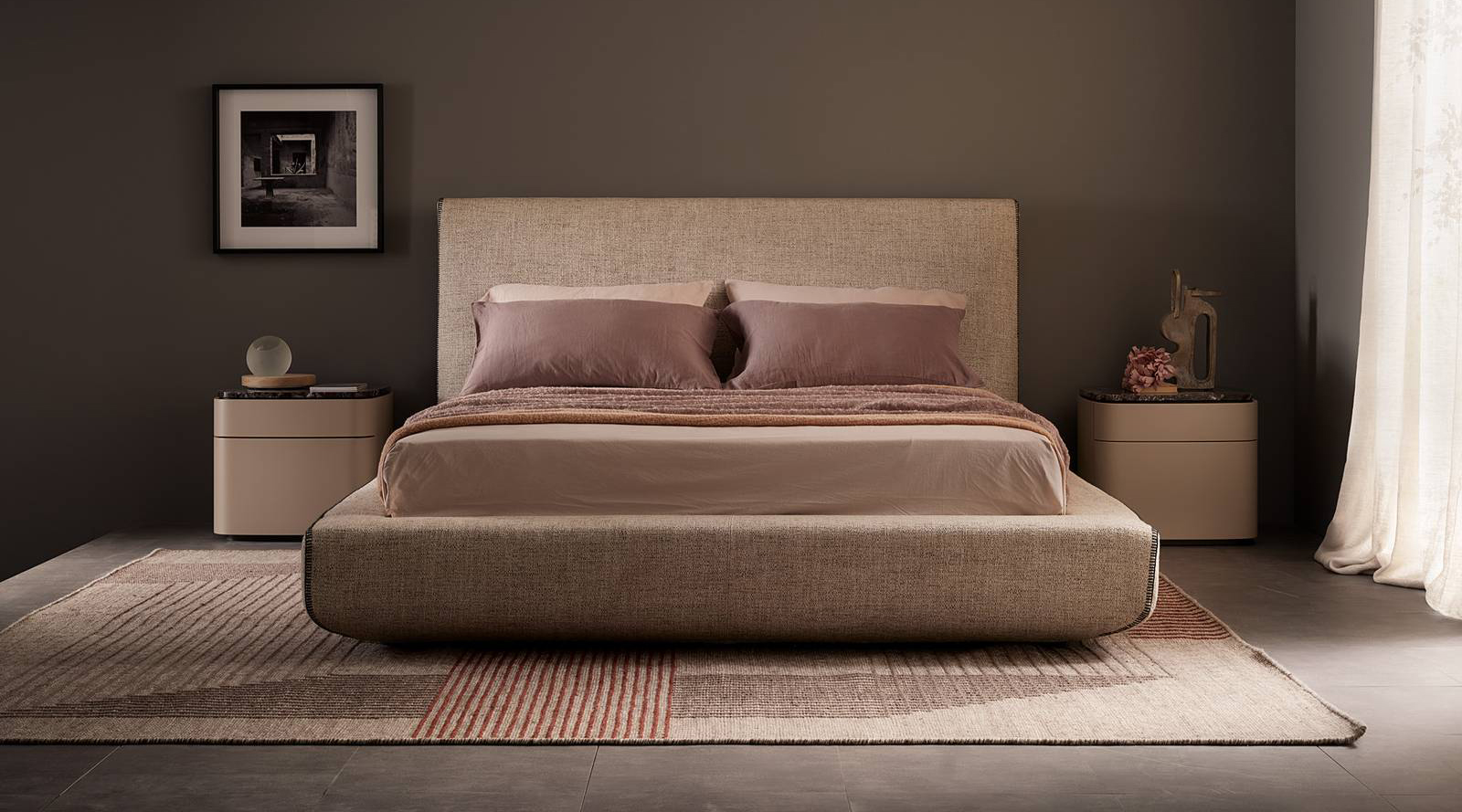 Una testata alta e imponente per il letto Lullaby di Lema che ha una linea geometrica resa confortevole dalle imbottiture in poliuretano indeformabile; è completamente rivestito in tessuto sfoderabile. La cucitura lungo i bordi si trasforma in un elemento decorativo. Misura L 242 x P 196 x H 112 cm. Prezzo a partire da 3.392 euro. https://www.lemamobili.com