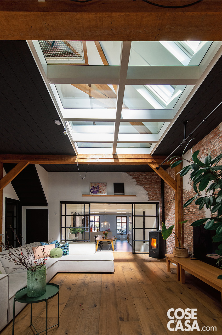 SOGGIORNO CON AFFACCIO SUL GIARDINOL’ampia zona giorno è organizzata come uno spazio fluido e conviviale, completamente aperto verso l’esterno grazie a grandi vetrate scorrevoli che conducono direttamente in giardino. Gli infissi minimali in alluminio nero incorniciano il paesaggio e garantiscono la massima permeabilità visiva. Gli arredi, selezionati dalla proprietaria Jellina Detmar, mixano recupero e design nordico: divano modulare grigio, tavolino basso in legno naturale e tappeti in juta a trama grossa. Le pareti intonacate a calce e il pavimento in legno a listoni larghi contribuiscono all’atmosfera calda e naturale. SOGGIORNO CON AFFACCIO SUL GIARDINOL’ampia zona giorno è organizzata come uno spazio fluido e conviviale, completamente aperto verso l’esterno grazie a grandi vetrate scorrevoli che conducono direttamente in giardino. Gli infissi minimali in alluminio nero incorniciano il paesaggio e garantiscono la massima permeabilità visiva. Gli arredi, selezionati dalla proprietaria Jellina Detmar, mixano recupero e design nordico: divano modulare grigio, tavolino basso in legno naturale e tappeti in juta a trama grossa. Le pareti intonacate a calce e il pavimento in legno a listoni larghi contribuiscono all’atmosfera calda e naturale.