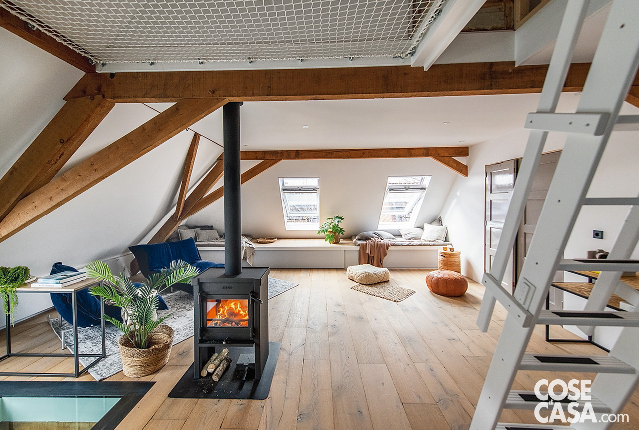 STUFA BIFACCIALE A CENTRO VOLUME Nel cuore del piano mansardato è stata installata una stufa che riscalda gli ambienti in modo uniforme. La posizione centrale e l’assenza di pareti divisorie permettono una diffusione ottimale del calore. Il rivestimento è in acciaio nero opaco, per un tocco industriale che contrasta con il legno chiaro delle travi. STUFA BIFACCIALE A CENTRO VOLUME Nel cuore del piano mansardato è stata installata una stufa che riscalda gli ambienti in modo uniforme. La posizione centrale e l’assenza di pareti divisorie permettono una diffusione ottimale del calore. Il rivestimento è in acciaio nero opaco, per un tocco industriale che contrasta con il legno chiaro delle travi.