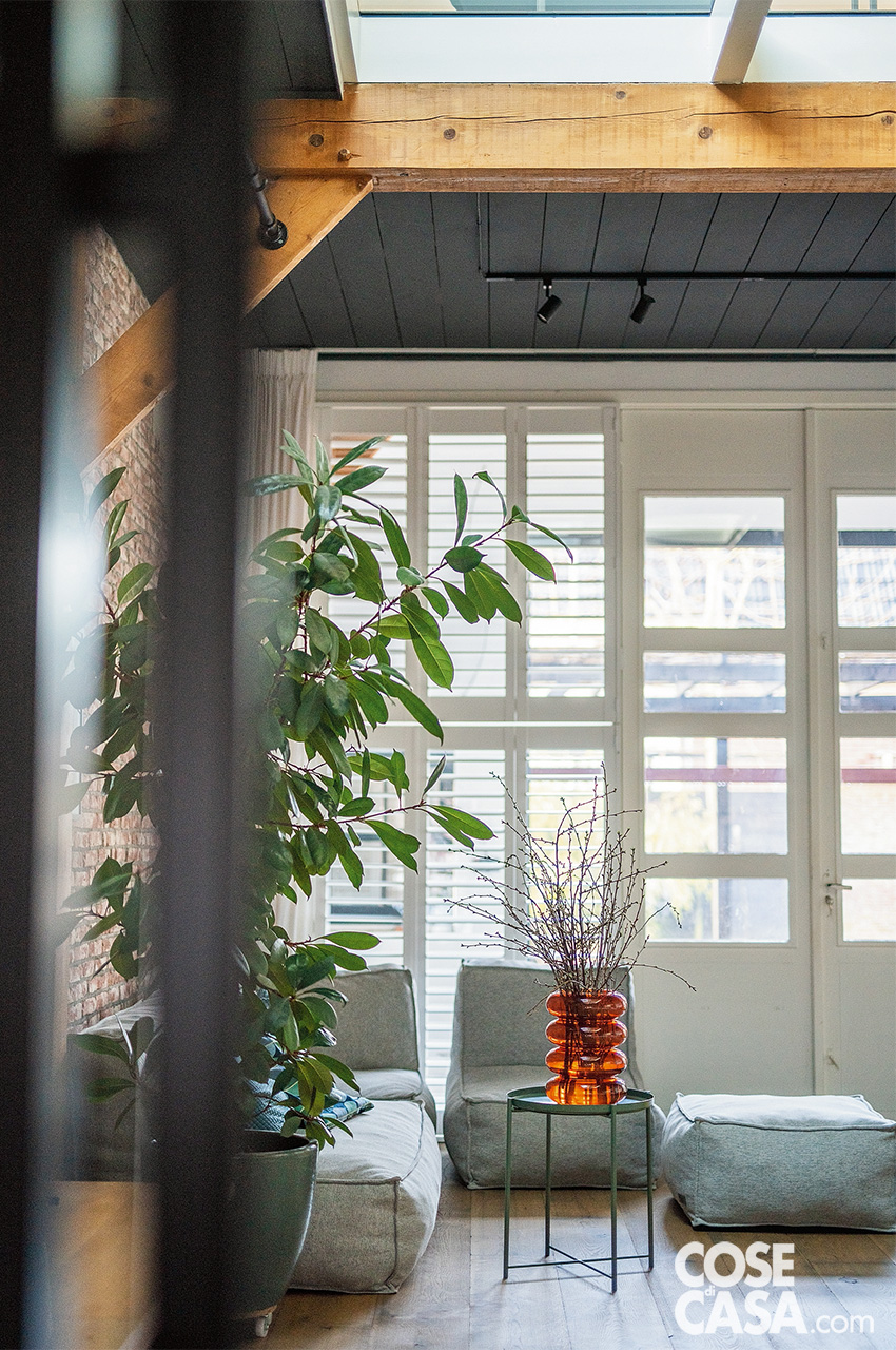 CONTROCAMPO DEL SOGGIORNO dove un altro tavolino verde Ikea e delle sedute imbottite grigie arredano la zona d'angolo vicino alle portefinestre bianche. CONTROCAMPO DEL SOGGIORNO dove un altro tavolino verde Ikea e delle sedute imbottite grigie arredano la zona d'angolo vicino alle portefinestre bianche.