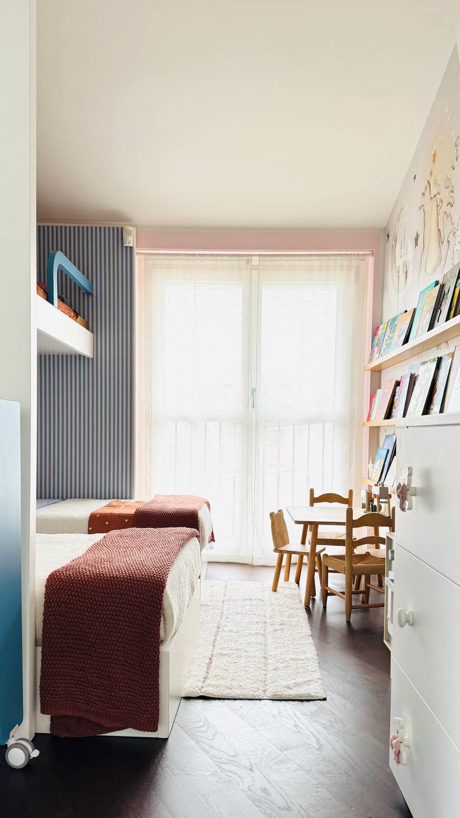 Ai piedi dei due letti, c'è il tavolo con le seggioline, che una volta tolta la culla libererà la zona notte per passare al di là del divisorio,