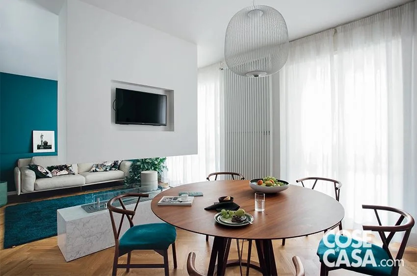 In questa stanza molto luminosa per la presenza della grande vetrata, risultano molto eleganti le quattro sedie che contornano il tavolo da pranzo rotondo e che hanno la seduta in velluto color petrolio su una struttura in legno scuro. In pendant con esse sono dello stesso colore anche una porzione della parete e il tappeto nella zona conversazione, mentre tutto il resto è dominato dal bianco di pareti, soffitto, divano, radiatore e camino centrale e dal legno del parquet e del tavolo, con un effetto di grande raffinatezza.
Progetto arch. Manuel Romeo, SMARCK Studio, Milano http://www.smarckstudio.com - Foto Studio Roy, styling Laura Mauceri In questa stanza molto luminosa per la presenza della grande vetrata, risultano molto eleganti le quattro sedie che contornano il tavolo da pranzo rotondo e che hanno la seduta in velluto color petrolio su una struttura in legno scuro. In pendant con esse sono dello stesso colore anche una porzione della parete e il tappeto nella zona conversazione, mentre tutto il resto è dominato dal bianco di pareti, soffitto, divano, radiatore e camino centrale e dal legno del parquet e del tavolo, con un effetto di grande raffinatezza.
Progetto arch. Manuel Romeo, SMARCK Studio, Milano http://www.smarckstudio.com - Foto Studio Roy, styling Laura Mauceri