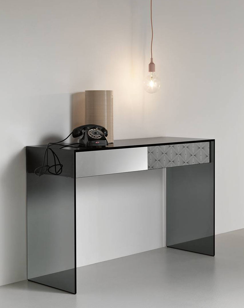 La consolle Gotham di Tonelli Design ha la struttura completamente realizzata in vetro fumé che lascia intravedere i cassetti in legno nero, dotati di chiusura soft e del frontale in specchio fumé. É disponibile anche con caricabatterie a induzione integrato per dare vita ad un postazione di ricarica, funzionale e raffinata, nell'ingresso. Misura L 120 x P 45 x H 80 cm. Prezzo 1.927.60 euro. https://tonellidesign.it La consolle Gotham di Tonelli Design ha la struttura completamente realizzata in vetro fumé che lascia intravedere i cassetti in legno nero, dotati di chiusura soft e del frontale in specchio fumé. É disponibile anche con caricabatterie a induzione integrato per dare vita ad un postazione di ricarica, funzionale e raffinata, nell'ingresso. Misura L 120 x P 45 x H 80 cm. Prezzo 1.927.60 euro. https://tonellidesign.it