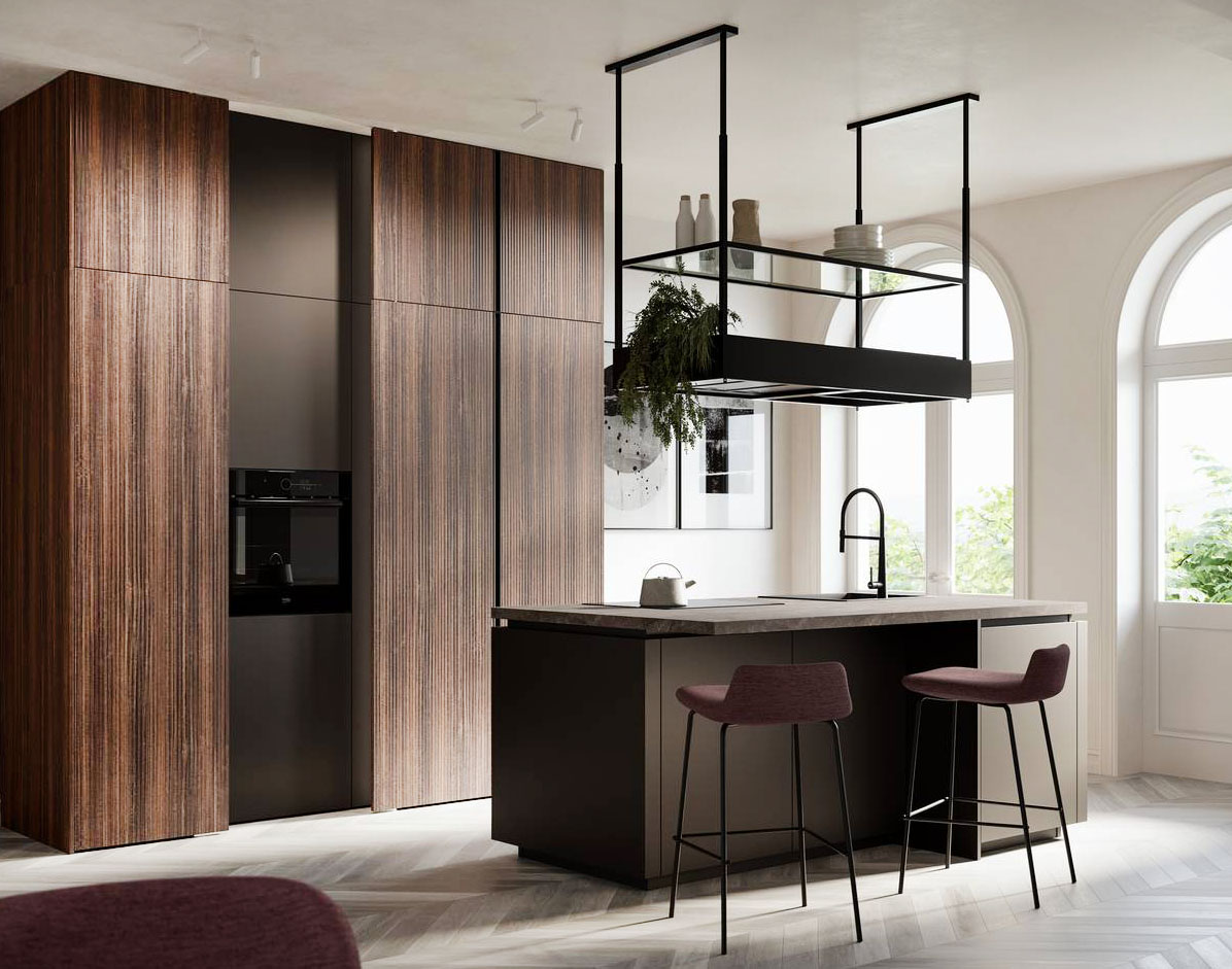 La piccola isola della cucina Kalì di Arredo3 è posizionata a centro stanza ed è sormontata dalla scenografica cappa Spazio di Falmec. Le basi dell'isola sono in PET riciclato bronzo dark; il top, completo di piano cottura e lavello, fuoriesce per creare anche uno spazio snack. A parete trova posto il blocco colonne realizzato in laminato riga noce che, con le sue venature verticali, ne enfatizza l’altezza. Prezzo su richiesta. https://www.arredo3.it