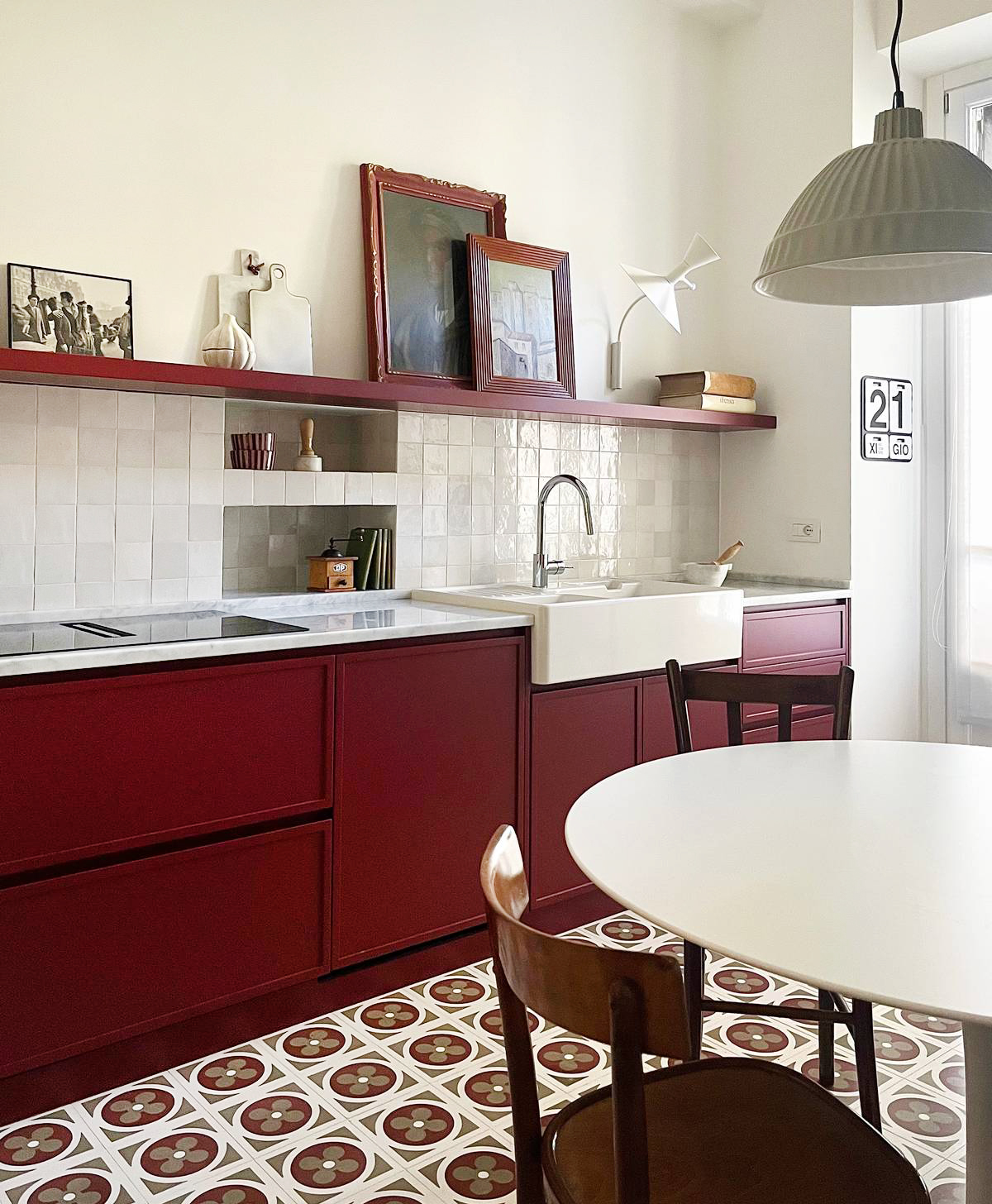 Quando il pavimento è fortemente decorato e colorato e diventa protagonista decorativo, la palette dei mobili deve farsi misurata. Succede con le cementine, ma anche con le graniglie e con tutte le piastrelle in gres con decori simili. In tutti questi casi diventa difficile inserire un’altra fantasia ed è quindi meglio puntare su qualcosa di sobrio in abbinamento. Le pareti e i mobili possono essere bianchi o, al massimo, si può usare un colore, ma tra quelli presenti nel decoro. In questo progetto (di Guia Bartolozzi e Ludovica Donvito) la scelta per la laccatura delle ante è caduta su un tono bordeaux ripreso dal disegno del pavimento, per un effetto raffinato e coerente. Aggiungere un'altra tinta sarebbe stato eccessivo. Le pareti neutre lasciano spazio alla complessità grafica delle piastrelle, restituendo un ambiente equilibrato e ricco di personalità.