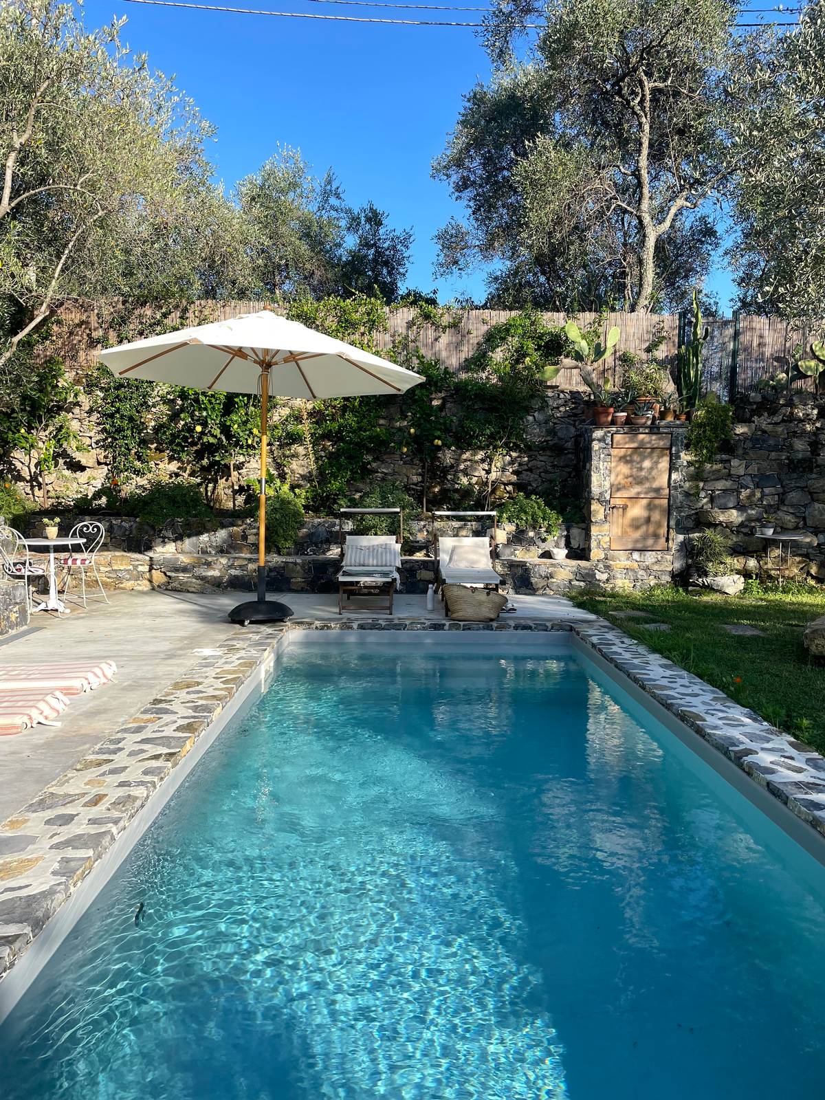 In un giardino ligure, tra gli ulivi, in una situazione molto semplice e rurale, non si voleva che la piscina snaturasse gli esterni della casa e anzi doveva essa stessa diventare parte integrante del paesaggio, come se ci fosse sempre stata. La forma è lunga e stretta, circa 3 metri di larghezza x 8 metri di lunghezza. Una dimensione contenuta, dettata dallo spazio a disposizione, ma piacevole per rinfrescarsi e fare il bagno. In un giardino ligure, tra gli ulivi, in una situazione molto semplice e rurale, non si voleva che la piscina snaturasse gli esterni della casa e anzi doveva essa stessa diventare parte integrante del paesaggio, come se ci fosse sempre stata. La forma è lunga e stretta, circa 3 metri di larghezza x 8 metri di lunghezza. Una dimensione contenuta, dettata dallo spazio a disposizione, ma piacevole per rinfrescarsi e fare il bagno.