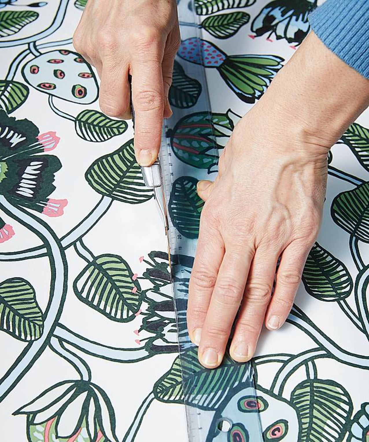 Appoggiare la carta da parati su una superficie rigida, come un asse di legno
o un tappetino da taglio. Con l’aiuto della riga e del cutter inciderla seguendo le linee tracciate. Premere bene sul cutter o in modo da effettuare un taglio preciso. Appoggiare la carta da parati su una superficie rigida, come un asse di legno
o un tappetino da taglio. Con l’aiuto della riga e del cutter inciderla seguendo le linee tracciate. Premere bene sul cutter o in modo da effettuare un taglio preciso.