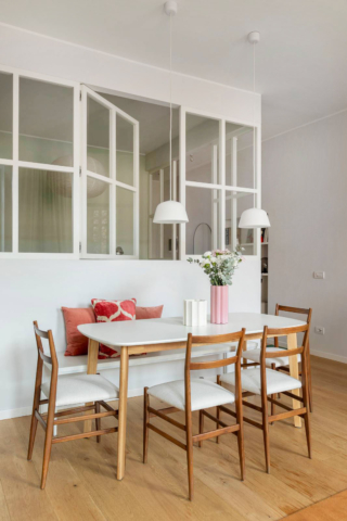 Una finestra apribile tra due ambienti - In questa casa molto piccola non c’era lo spazio per creare una vera camera da letto separata: si è scelto quindi di fare una lunga vetrata per dare luce e aria alla zona notte, che si affaccia sul soggiorno. La vetrata in legno è laccata di colore bianco, con un disegno a riquadri di stile industriale. In questo modo si è evitato il divano letto in sala, e - anche se aperta - la zona dove si dorme ha una sua intimità. Una finestra apribile tra due ambienti - In questa casa molto piccola non c’era lo spazio per creare una vera camera da letto separata: si è scelto quindi di fare una lunga vetrata per dare luce e aria alla zona notte, che si affaccia sul soggiorno. La vetrata in legno è laccata di colore bianco, con un disegno a riquadri di stile industriale. In questo modo si è evitato il divano letto in sala, e - anche se aperta - la zona dove si dorme ha una sua intimità.