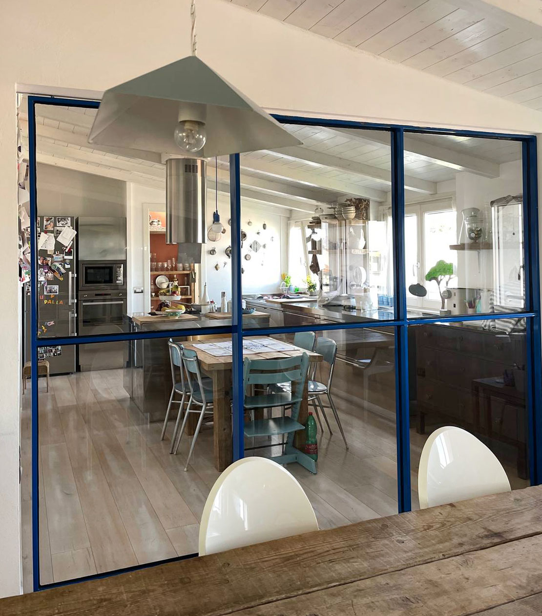La vetrata blu - Scelta molto decisa per questa grande vetrata tra cucina e soggiorno di un appartamento in mansarda è stata laccata in un intenso colore Blu Klein. Il colore è forte, ma dato che lo spessore del ferro molto sottile rimane una presenza non troppo invasiva. La particolarità è che questo colore non è poi stato ripreso in nessun altro elemento di interior della casa: in questo modo la vetrata rimane protagonista indiscussa di tutta la zona giorno. La vetrata blu - Scelta molto decisa per questa grande vetrata tra cucina e soggiorno di un appartamento in mansarda è stata laccata in un intenso colore Blu Klein. Il colore è forte, ma dato che lo spessore del ferro molto sottile rimane una presenza non troppo invasiva. La particolarità è che questo colore non è poi stato ripreso in nessun altro elemento di interior della casa: in questo modo la vetrata rimane protagonista indiscussa di tutta la zona giorno.