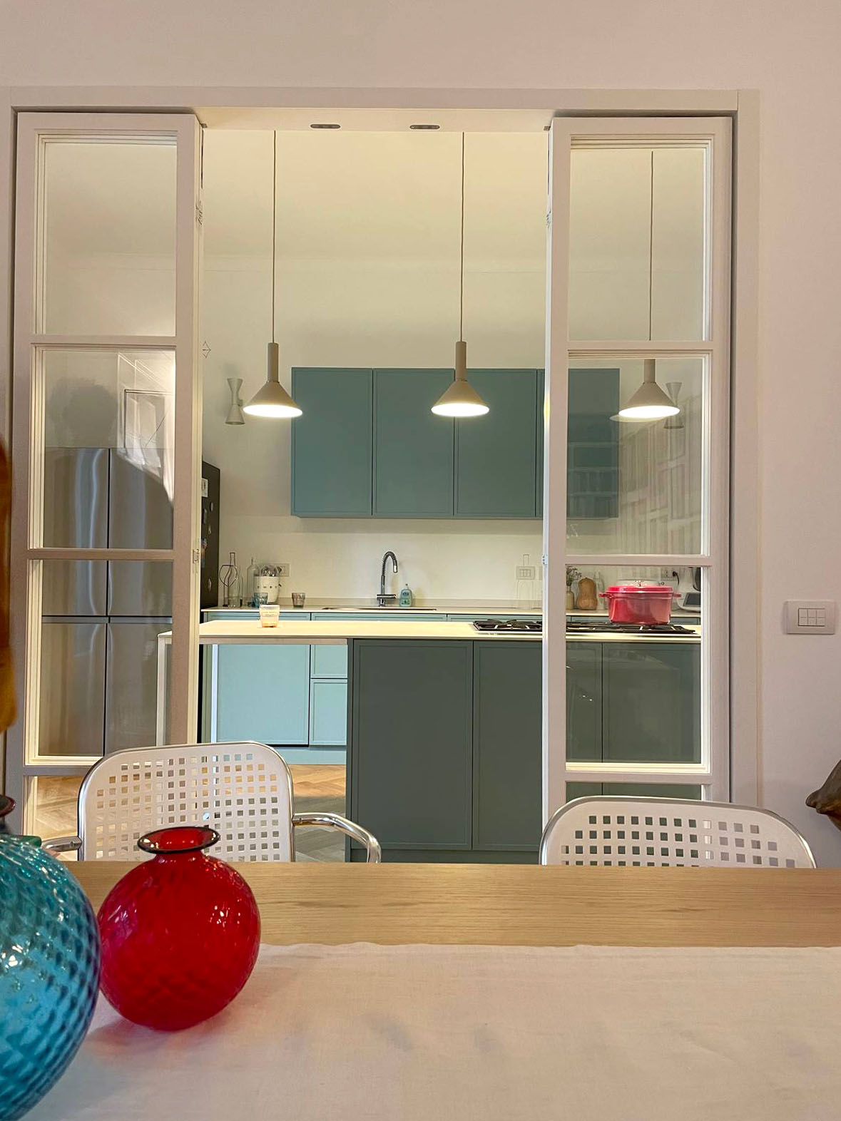 Una vetrata in legno ma essenziale - In un appartamento dallo stile contemporaneo cucina e sala da pranzo sono divise da una vetrata in legno dal disegno minimal ed essenziale. Potrebbe sembrare una vetrata in ferro, ma il legno le dona un aspetto più raffinato e adatto a questa casa. Tutte le pannellature sono vetrate e trasparenti, e le quattro ante sono apribili completamente a pacchetto, soluzione che consente di trasformare il passaggio in un’apertura di circa 2 metri di larghezza, anche se nell’utilizzo quotidiano vengono aperte solo le due porte centrali, che si ribaltano sulle laterali grazie alle cerniere a 180 gradi. Una vetrata in legno ma essenziale - In un appartamento dallo stile contemporaneo cucina e sala da pranzo sono divise da una vetrata in legno dal disegno minimal ed essenziale. Potrebbe sembrare una vetrata in ferro, ma il legno le dona un aspetto più raffinato e adatto a questa casa. Tutte le pannellature sono vetrate e trasparenti, e le quattro ante sono apribili completamente a pacchetto, soluzione che consente di trasformare il passaggio in un’apertura di circa 2 metri di larghezza, anche se nell’utilizzo quotidiano vengono aperte solo le due porte centrali, che si ribaltano sulle laterali grazie alle cerniere a 180 gradi.