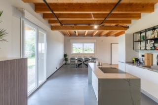 La cucina è lineare e ha di fronte l'isola, con zona cottura e piano di lavoro. La portafinestra a due ante è il modello Konfortline di WnD. La zona cucina è illuminata dallo scorrevole Slide Plus La cucina è lineare e ha di fronte l'isola, con zona cottura e piano di lavoro. La portafinestra a due ante è il modello Konfortline di WnD. La zona cucina è illuminata dallo scorrevole Slide Plus