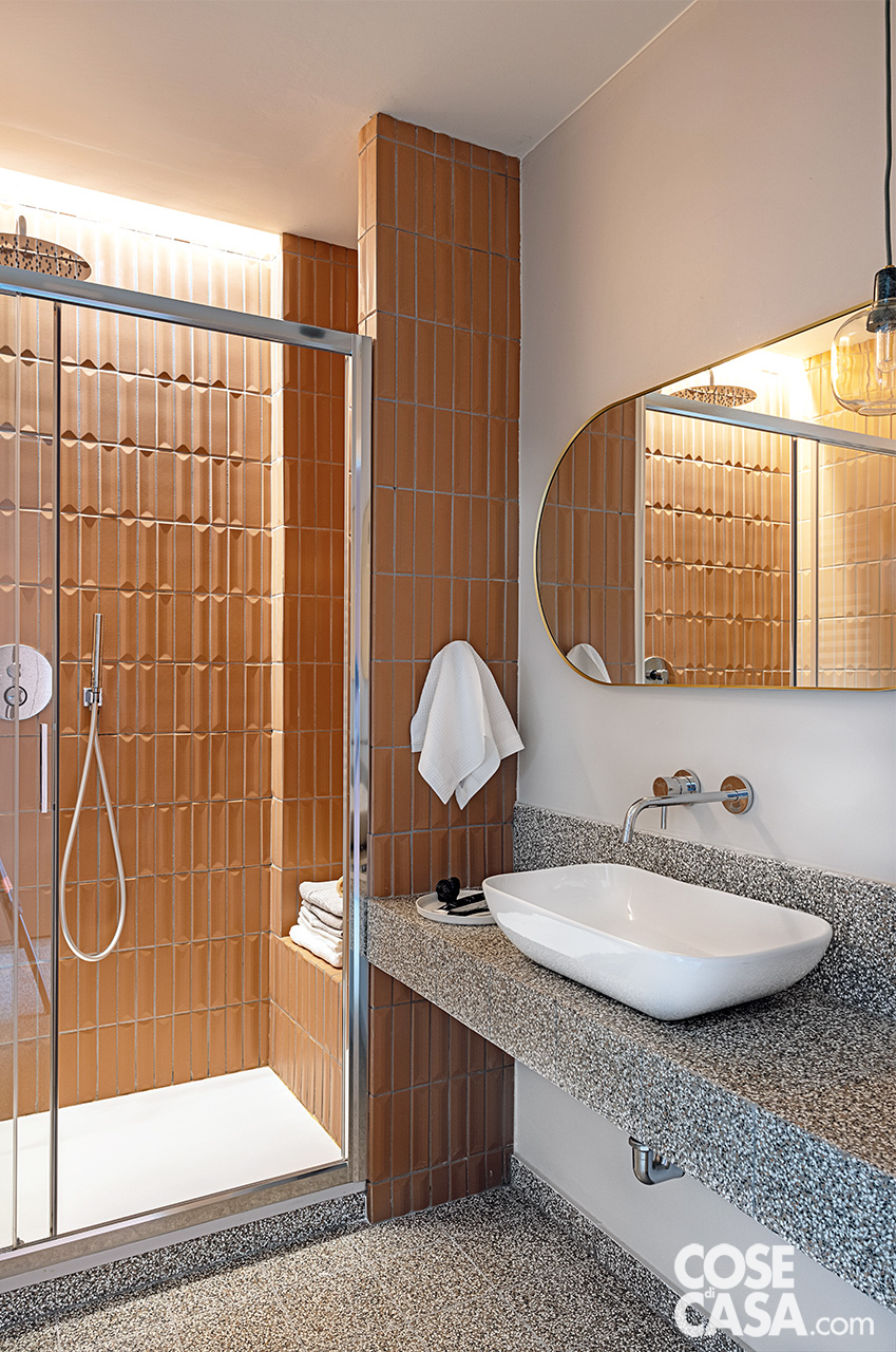 bagno con rivestimenti color terracotta e graniglia