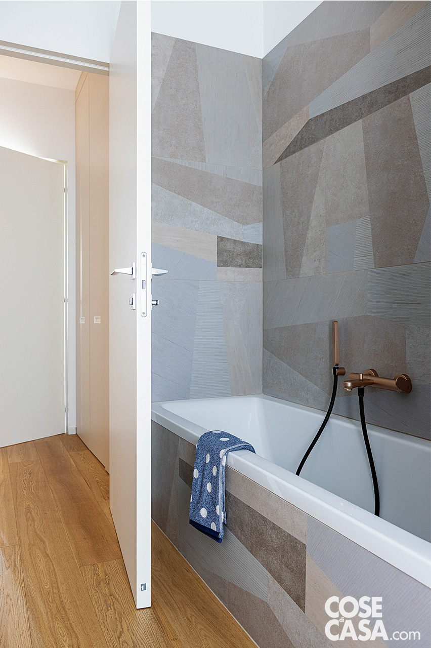 bagno con vasca e rivestimenti in stile geometrico