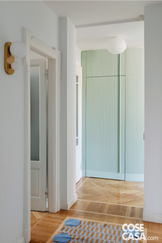 Parete cannettata verde pastello che "nasconde" lavanderia e guardaroba