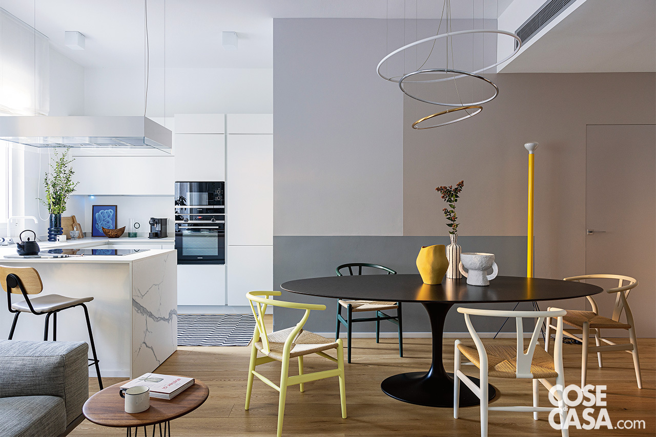 cucina bianca con penisola e tavolo da pranzo ovae nero