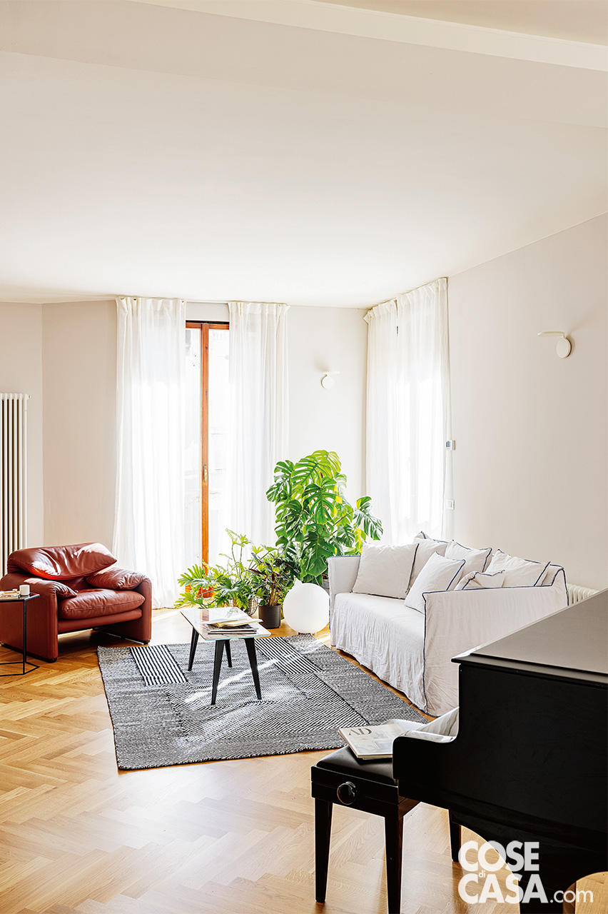 divano bianco e poltrona in pelle color mattone