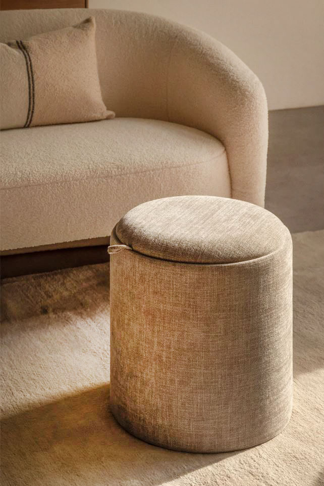 Come poggiapiedi tra i divani Ha una forma cilindrica il pouf contenitore Berkeleni di Sklum che è completamente rivestito in tessuto in una colorazione in gradazione con il divano. Permette di avere a portata di mano un plaid, gli accessori elettronici affinché siano ben protetti o i giocattoli per i più piccoli. Inoltre, basta girare il coperchio superiore per trasformarlo in un pratico vassoio in legno di frassino. Misura Ø 40 x H 44 cm. Prezzo 80,95 euro.  https://www.sklum.com