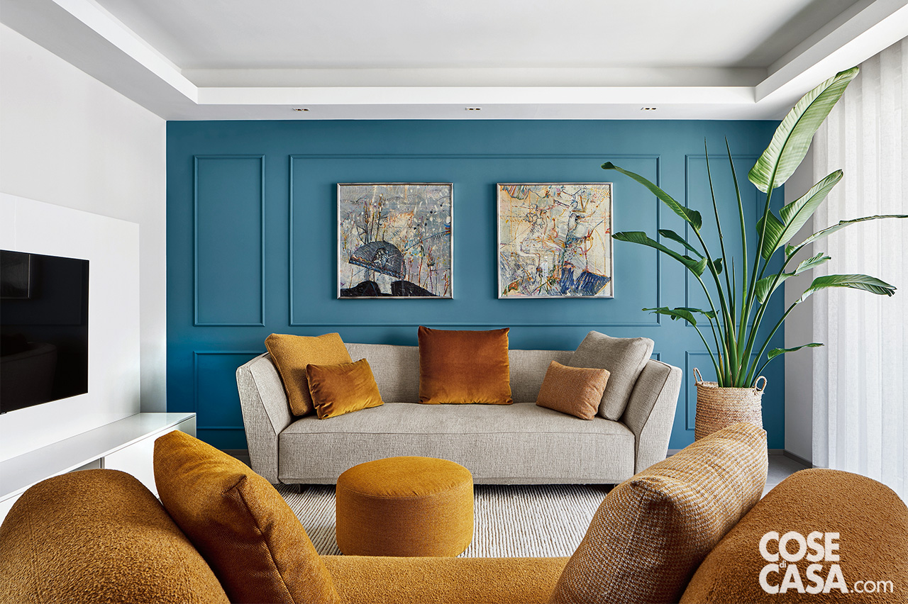 soggiorno con divano beige e parete azzurra