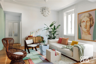 Soggiorno con triple finestre, divano bianco e un tappeto che fa da legante cromatico