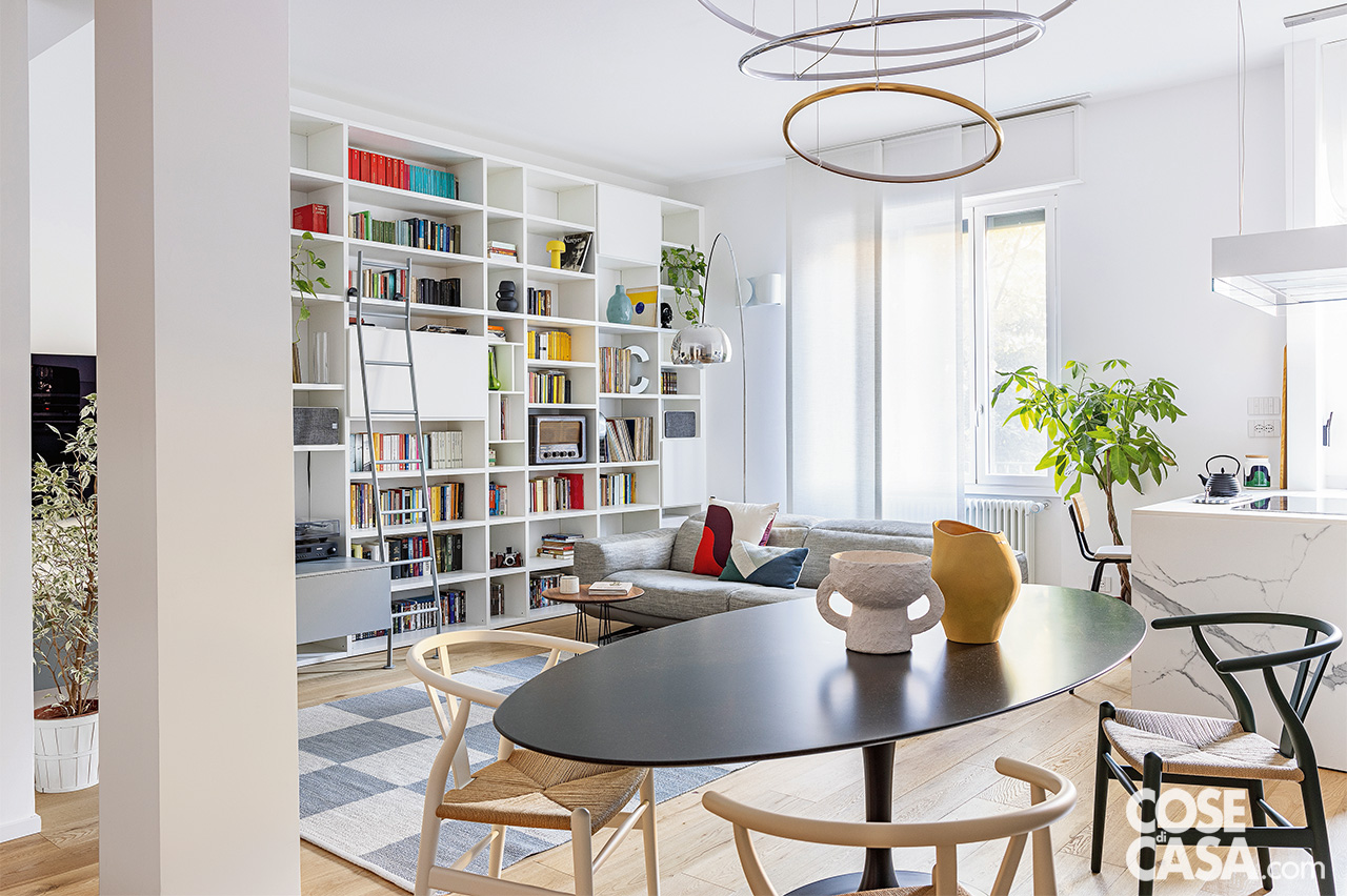 zona conversazione del living con libreria a giorno bianca