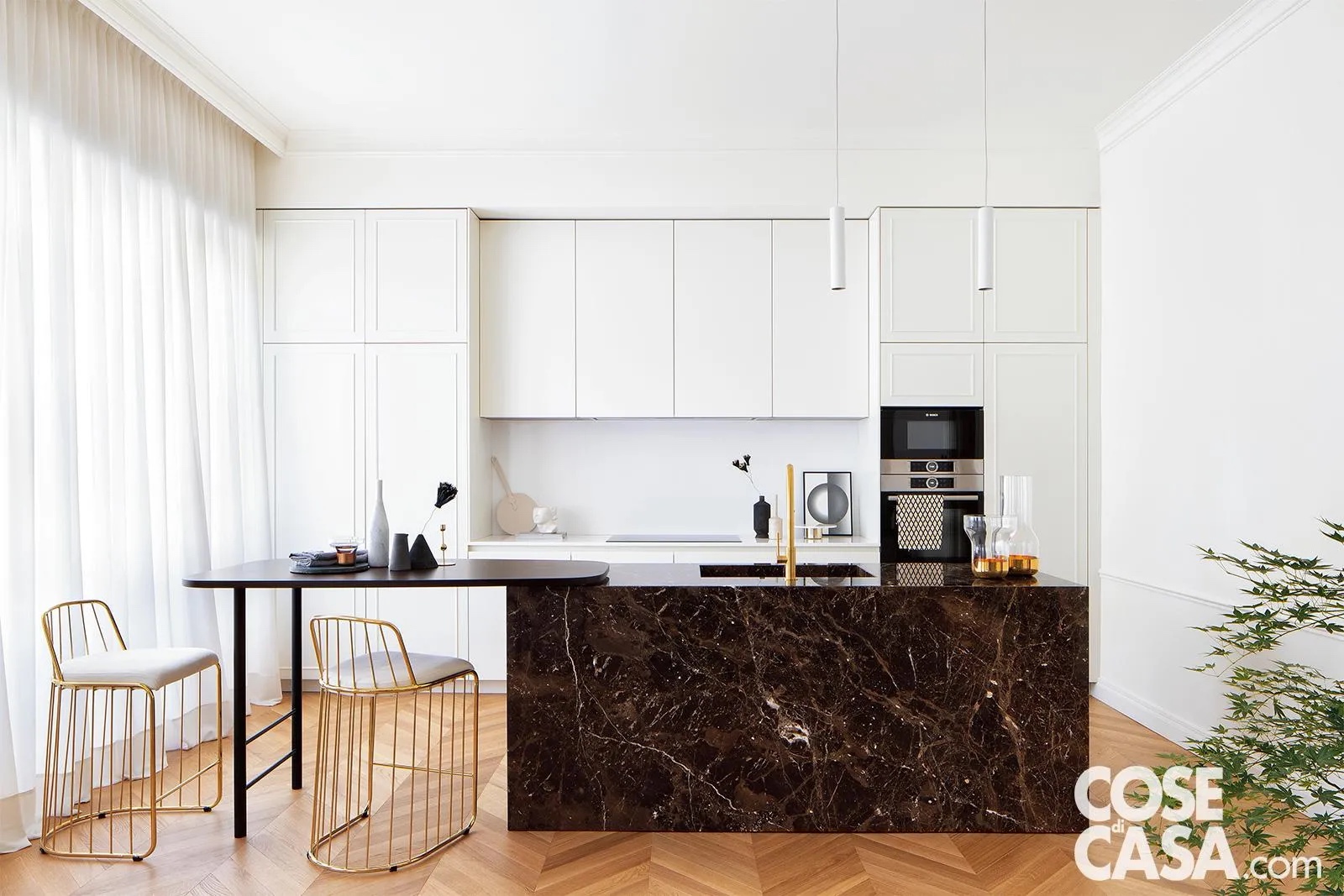 In questo living open space con cucina a vista di colore bianco, l'isola centrale è in elegante marmo nero e termina con un tavolo in legno laccato nero, che funge da banco snack e colazione. Come sedute, sono stati scelti degli sgabelli imbottiti che presentano una struttura metallica color oro e che per la via della forma hanno un gusto rétro. L'insieme di bianco, nero e oro dona alla cucina una grande eleganza.
Progetto Studio Tenca Associati, Milano, Tel. 02/3319239 http://www.studiotenca.it - Foto Riccardo Gasperoni - Styling Irene Baratto In questo living open space con cucina a vista di colore bianco, l'isola centrale è in elegante marmo nero e termina con un tavolo in legno laccato nero, che funge da banco snack e colazione. Come sedute, sono stati scelti degli sgabelli imbottiti che presentano una struttura metallica color oro e che per la via della forma hanno un gusto rétro. L'insieme di bianco, nero e oro dona alla cucina una grande eleganza.
Progetto Studio Tenca Associati, Milano, Tel. 02/3319239 http://www.studiotenca.it - Foto Riccardo Gasperoni - Styling Irene Baratto