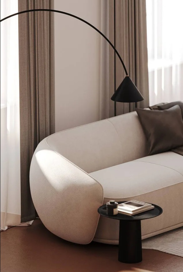 Morbido ed elegante il divano (modello Bolzano di BoConcept) in una tonalità calda bianco avorio. Nera invece la lampada ad arco che illumina la zona conversazione e il tavolino.