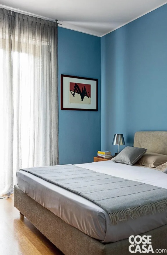 Il letto rivestito in tessuto écru è di Flou, abbinato a pareti tinteggiate con idropittura di Sikkens, in una tonalità di azzurro intenso. Completo lenzuola, copripiumino, plaid e cuscini sono di Mirabello Carrara. La lampada da tavolo sul comodino è Ktribe T2 di Flos in finitura argento alluminizzato. Il letto rivestito in tessuto écru è di Flou, abbinato a pareti tinteggiate con idropittura di Sikkens, in una tonalità di azzurro intenso. Completo lenzuola, copripiumino, plaid e cuscini sono di Mirabello Carrara. La lampada da tavolo sul comodino è Ktribe T2 di Flos in finitura argento alluminizzato.