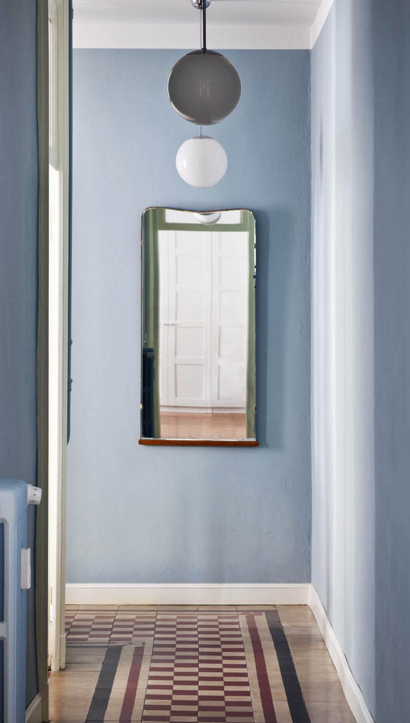 In questo corridoio con pavimento in cementine lo zoccolino laccato bianco termina con una lieve sagomatura che lo ingentilisce, rimanendo comunque semplice e non troppo ridondante. In questo caso contrasta sia con il pavimento che con le pareti, e diventa esso stesso una decorazione.