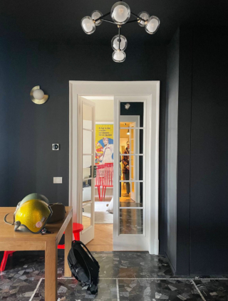 Una situazione simile a quella descritta nell’esempio sopra è quella di questo ingresso, con pareti e zoccolino dipinti entrambi di nero: il battiscopa, così, scompare totalmente sulla parete della stessa tinta.