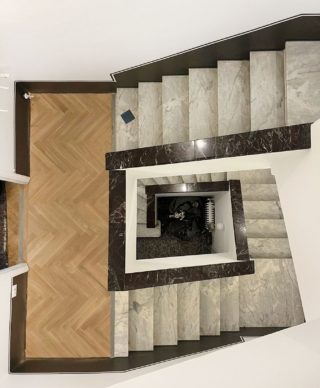 In questo esempio, visibile dal pianerottolo, lo zoccolino è sostituito da una fascia dipinta color grigio antracite, alta e continua, che accompagna la scala in modo uniforme, donandole carattere e coerenza visiva.