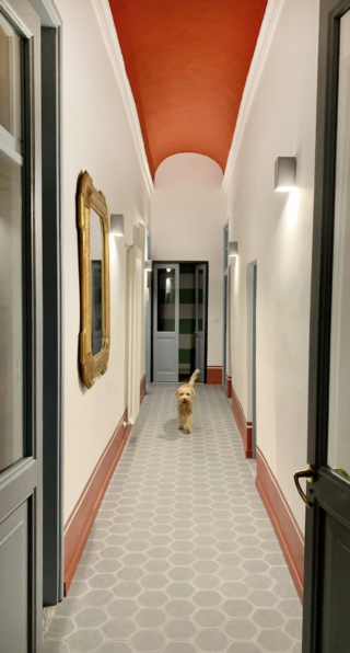 Una soluzione più insolita: zoccolino in legno basso, dipinto nello stesso colore della zoccolatura tipo boiserie alta 30 cm, che termina con una sottile modanatura, una righina che ingentilisce e caratterizza in modo deciso tutto il corridoio.